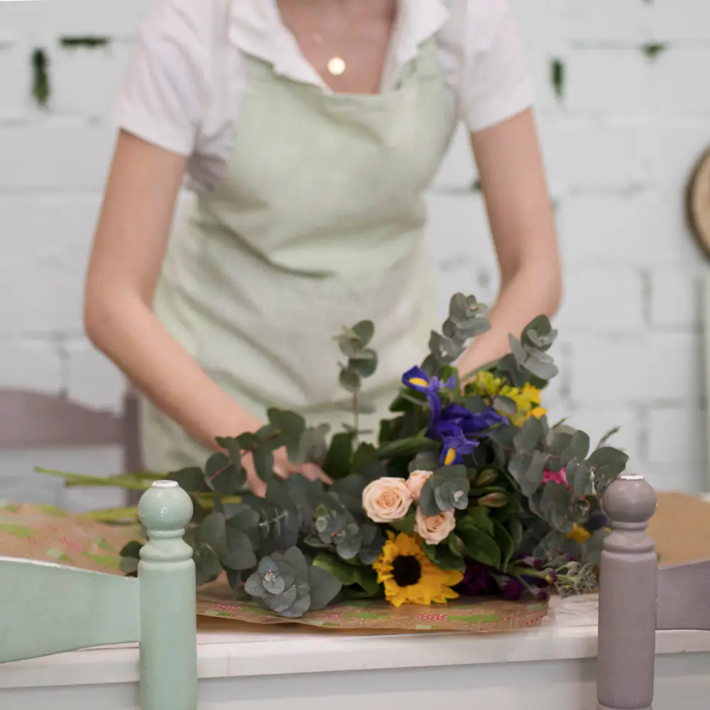 mujer florista preparando ramo flores